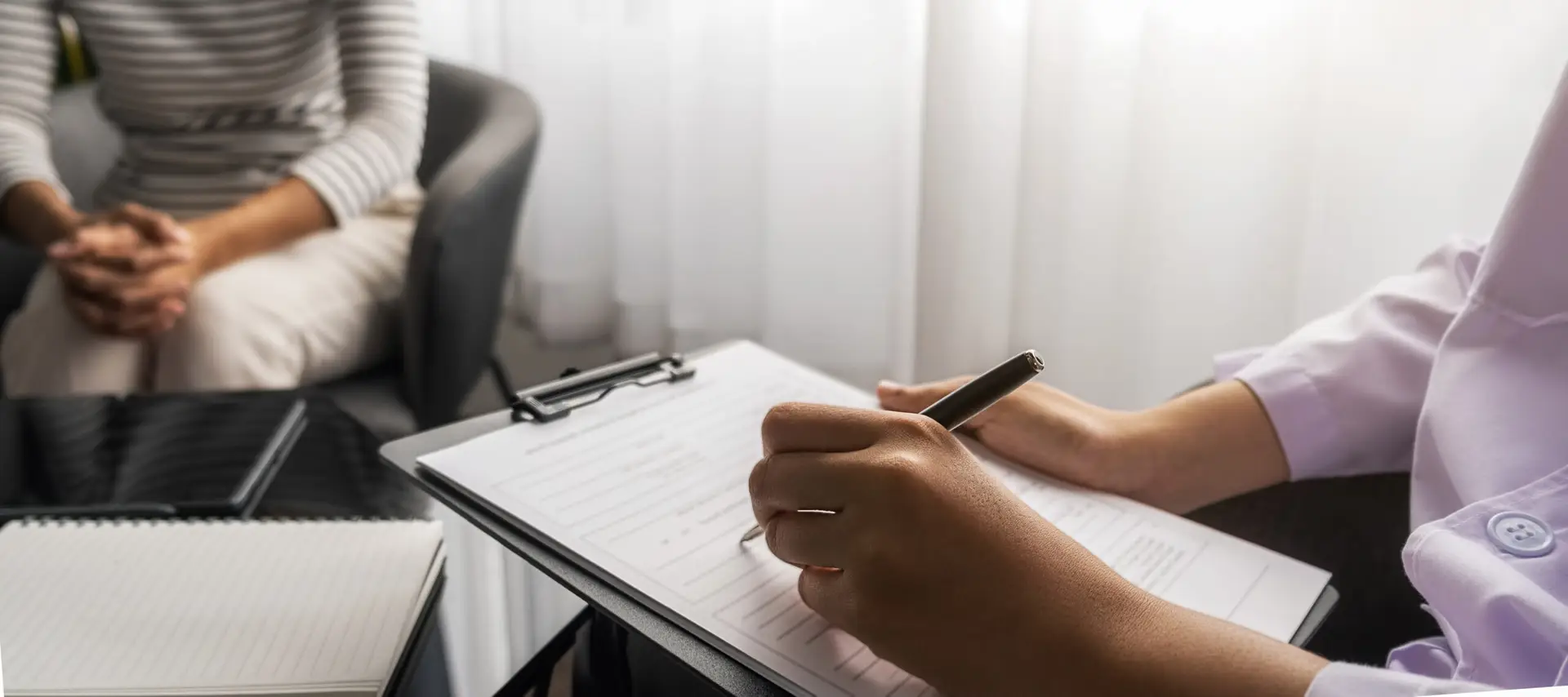Psychiatrist or professional psychologist consulting on diagnost - KLS Collective Therapy Group Therapist writing notes in session